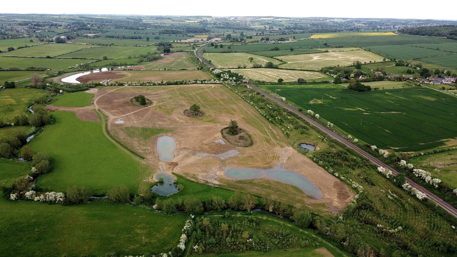 Restored UK wetland with infrastructure in the distance